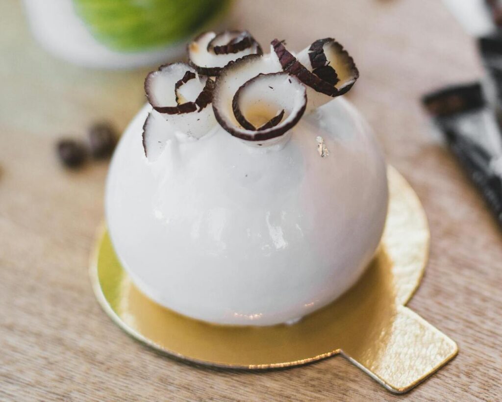 this image shows a unique cake in a round shape with coconut slices on top of it